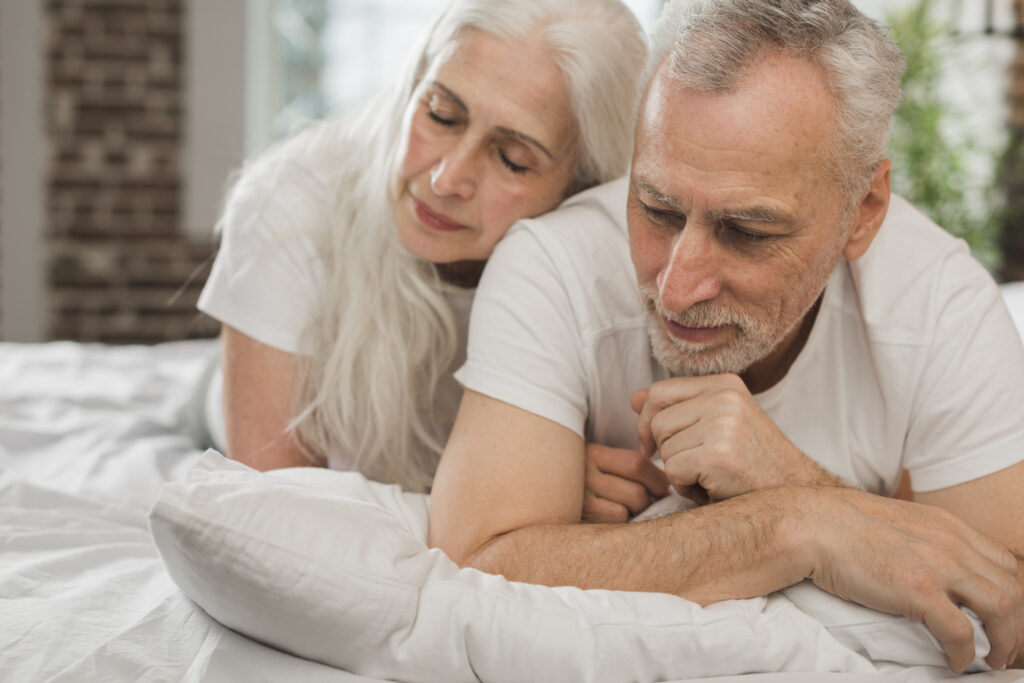 elderly couple laying in bed